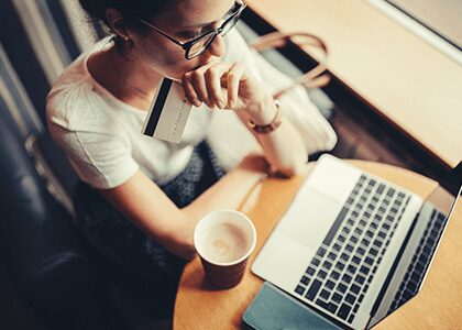 Woman with coffee paying for something online